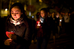 Claire Dorrance a Lockerbie Scholar from Scotland, kindles her flame while leading participants in the candlelight vigil to the Wall of Remembrance.