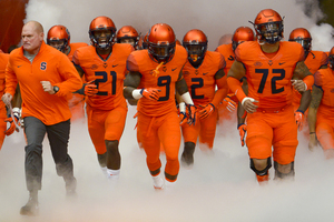 Chauncey Scissum (21), Brisly Estime (9),Wayne Morgan (2) and Ivan Foy (72) lead Syracuse out of the tunnel before taking on Wake Forest.