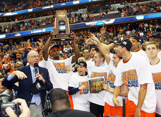 Head coach Jim Boeheim celebrates with players of the Syracuse Orange after their win over the Marquette Golden Eagles.